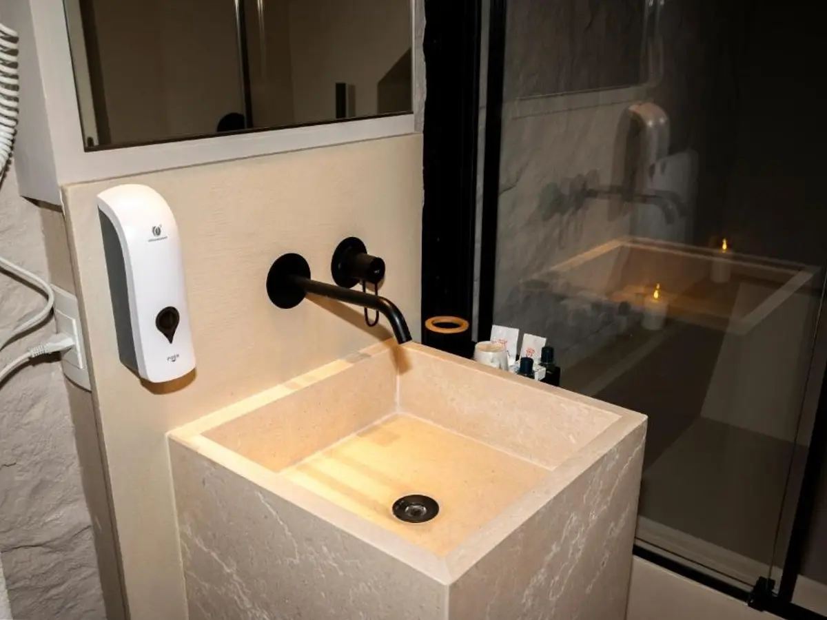 Bagno con lavabo in pietra e rubinetteria nera