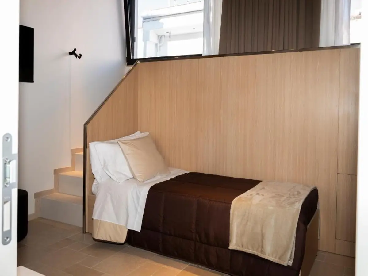 Camera con letto su soppalco in legno